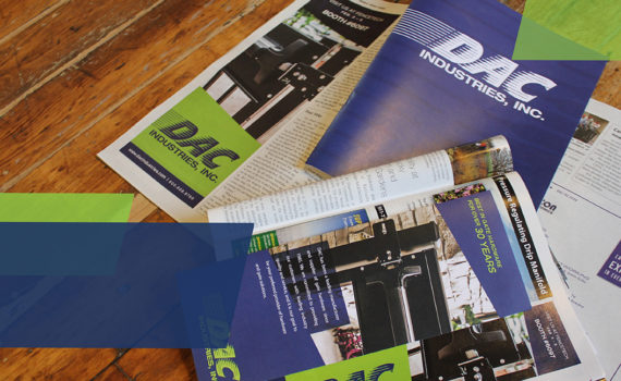 Multiple DAC Industry pamphlets and publications are spread out on a wooden desk.